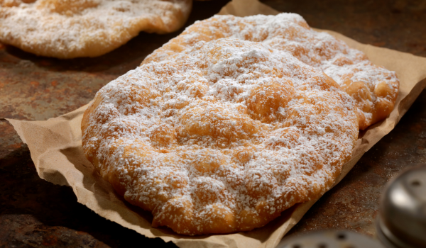 Crispy and fluffy Deep Fried Elephant Ears Recipe topped with powdered sugar, capturing the essence of a traditional fairground snack.