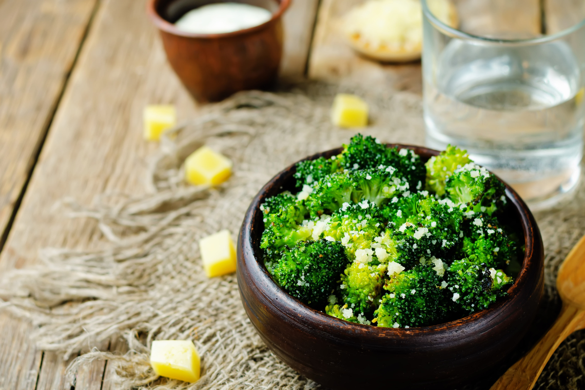 A closer look at golden-roasted broccoli garnished with cheese cubes in the background, highlighting the crisp texture and vibrant color, for beef and broccoli recipe