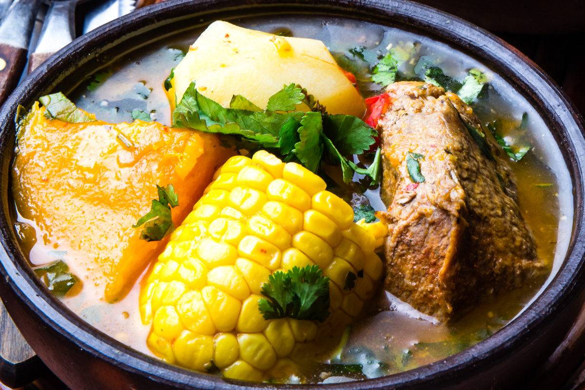 A close-up shot of a Caldo de Res bowl featuring tender beef, corn, and vegetables, topped with fresh cilantro, highlighting the soup’s warm and comforting texture
