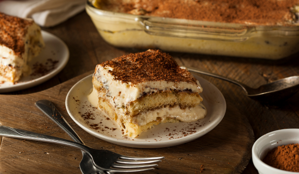 Easy Tiramisu: No-Bake Italian Dessert in Simple Steps 12 Homemade italian dessert served on a rustic wooden table, dusted with cocoa powder.