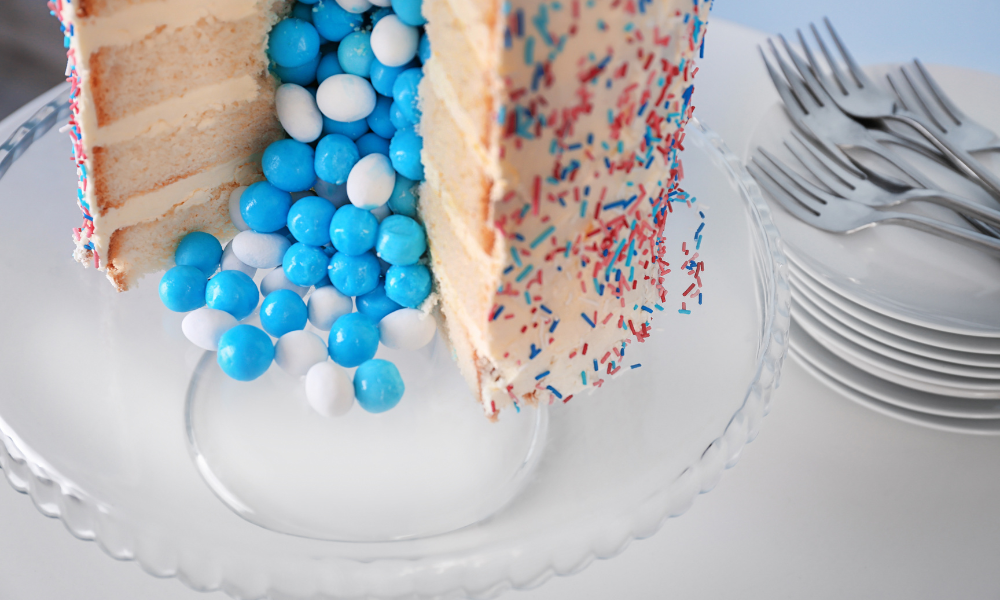 A close-up of a layered cake spilling blue candies, symbolizing the joy of a baby boy announcement.